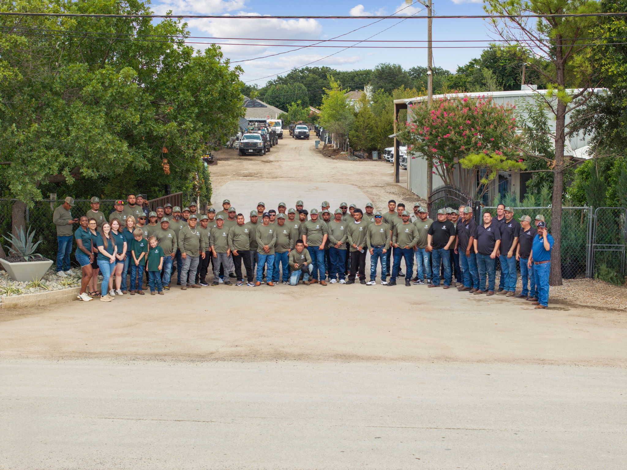 Landscaping crew in uniform working together on a large property